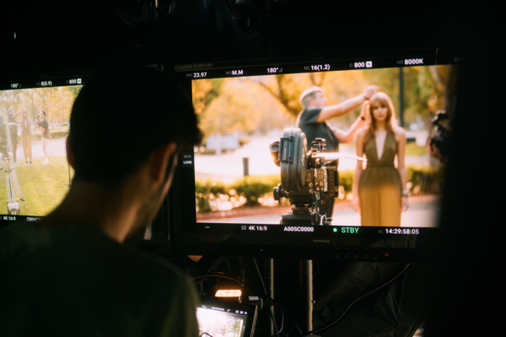 Filmmaker looks at monitor of cinematographer Shane Hurlbut using light meter for shooting film